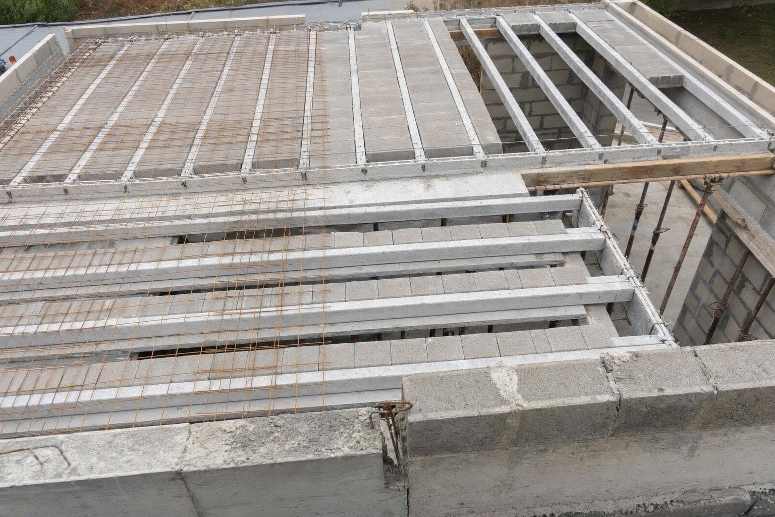 Plancher poutrelles-hourdis en cours de pose, entrevous béton alignés et treillis soudé