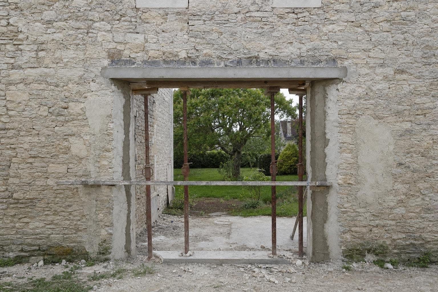 Ouverture neuve pour une baie dans une façade en pierre de craie, linteau béton et étais